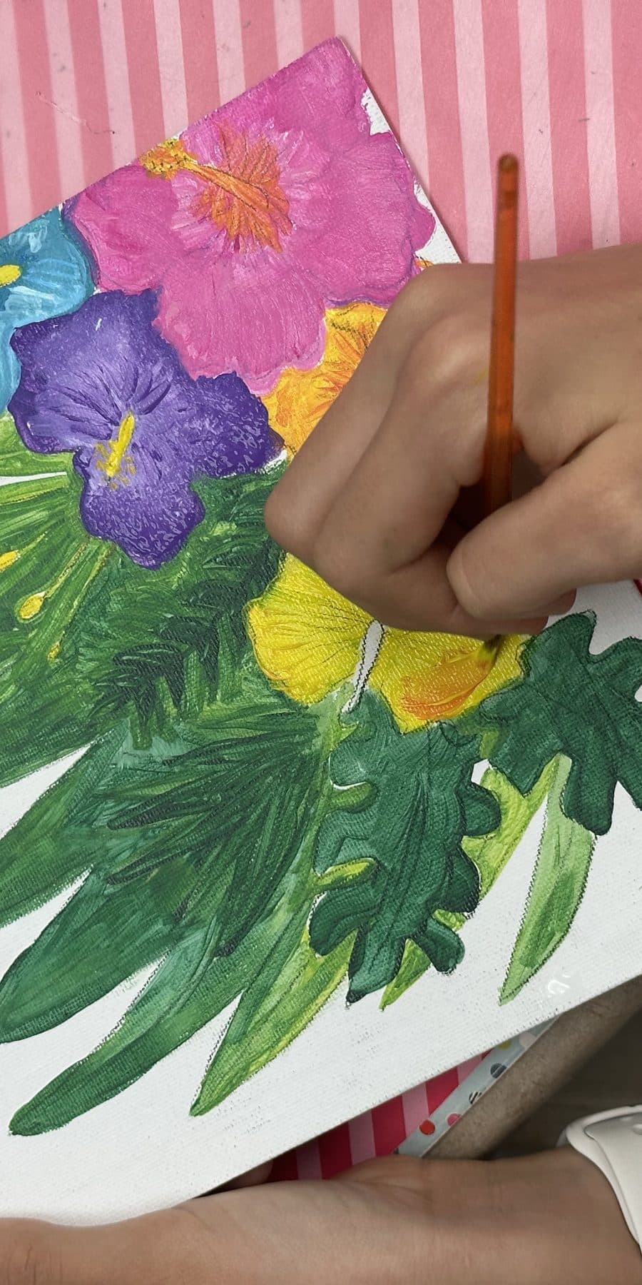 Student painting tropical hibiscus flowers